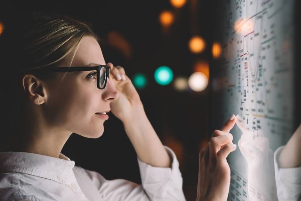 Frau mit Bildschirmbrille bei der Arbeit am Monitor